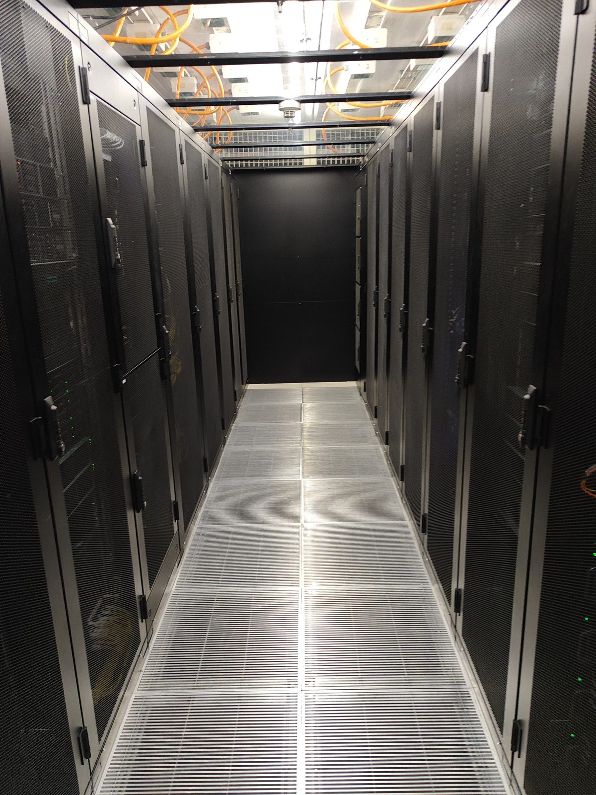 Rows of IT racks in the cold corridor of the standard colocation room in AlpineDC's private suites in Crissier